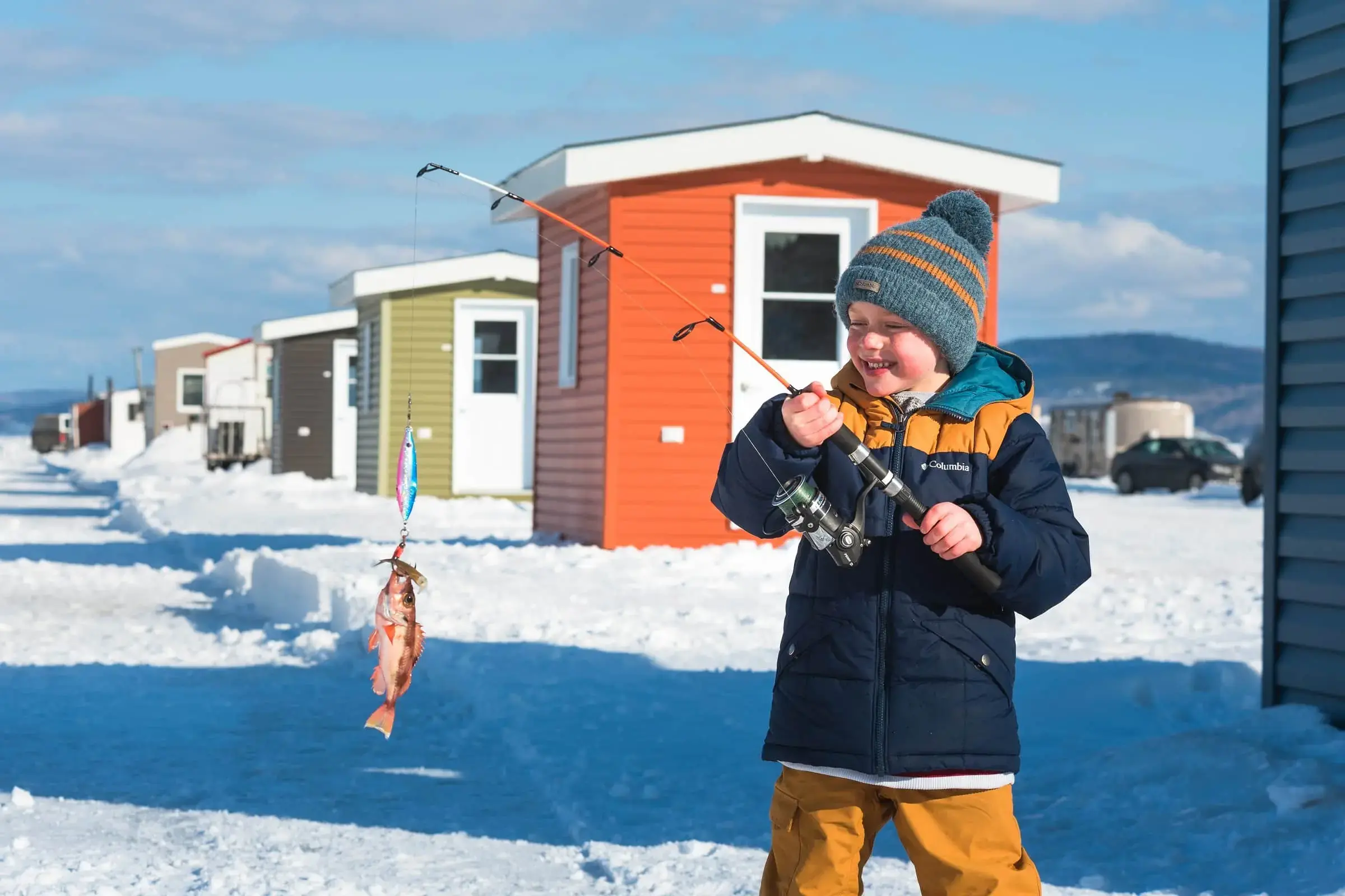 Un enfant fait de la pêche sur la glace.